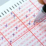 Completing a lottery ticket with a pen and hoping for quick riches